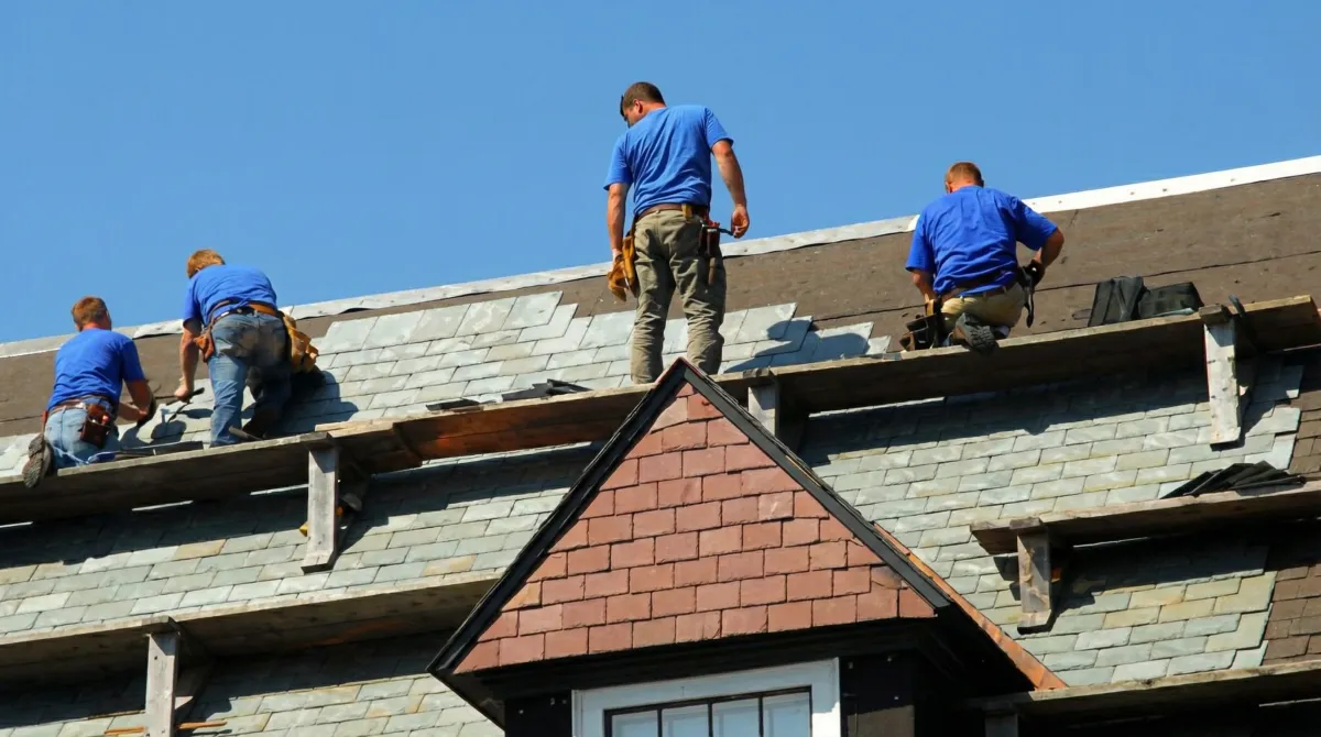 Roof replacement in progress with a team of professional contractors installing new shingles on a residential home in Providence, RI